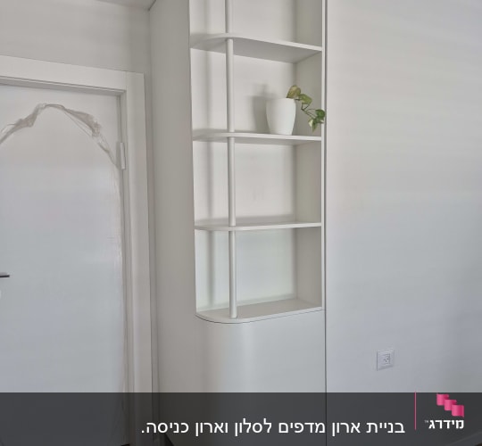 מדף לבן עם עציץ קטן על קיר